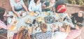 Top view of happy family eating and drinking wine at barbecue dinner outdoor - Multiracial people having fun at bbq sunday meal -