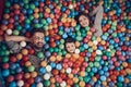 Top view. Happy family lying in pool with balls