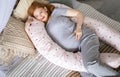 Top view happy future mother lying on comfortable bed hugging pillow for pregnant relaxing