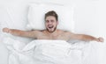 Top view. happy man waking up in a comfortable bed Royalty Free Stock Photo