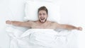 Top view. happy man waking up in a comfortable bed Royalty Free Stock Photo