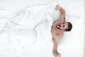 Top view. happy man waking up in a comfortable bed Royalty Free Stock Photo