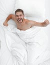 Top view. happy man waking up in a comfortable bed Royalty Free Stock Photo