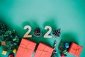 Top view Happy New Year 2020 Santa Claus hat, pine cones red gift box and colorful ball on green paper. Concept holiday background Royalty Free Stock Photo