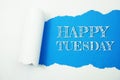 Happy Tuesday word on blue background with paper torn