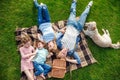 top view of happy young family with golden retriever dog resting on grass
