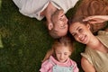 Top view of happy young parents with little daughter lying on green grass in summer park Royalty Free Stock Photo