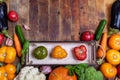 Top view harvest of fresh farm vegetables in small box and on old rustic weathered vintage wooden table Royalty Free Stock Photo