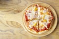 Top view of Hawaiian pizza homemade in wooden plate. Royalty Free Stock Photo