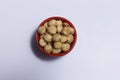 Top view of hazelnuts inside a red bowl isolated on white background Royalty Free Stock Photo