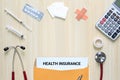 Top view of health insurance in letter envelope with stethoscope