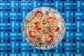 Top view of a healthy breakfast bowl with oatmeal, strawberries, and milk on a decorative blue table