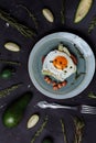 Top view of healthy breakfast scrambled eggs with bread and nuts in a plate on black background with avocado, rosemary, lime. Top Royalty Free Stock Photo