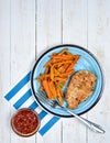 Top view of healthy fitness food, sweet potato fries, chicken steak and hot tomato sauce with chili. Light blue plate on