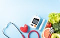 Top view of healthy food in plate with stethoscope and red heart for cholesterol diet and diabetes control on pastel blue Royalty Free Stock Photo