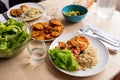 Top view of healthy, fresh, organic homemade table spread with cooked salmon, green salad, guacamole, , rice and fried platano on