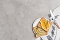 top view of healthy toasts with apple and orange slices on plate with fork and knife