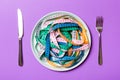 Top view of heap of colorful measuring tapes in plate on purple background. Diet concept with copy space Royalty Free Stock Photo