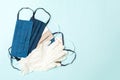Top view of a heap of homemade cotton masks and nitrile gloves on blue background. Personal protection concept with copy space Royalty Free Stock Photo