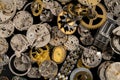 Top view of heap of metal internal parts of old clock. Dial, clockwork, bracelet, gears, cogwheels on black studio