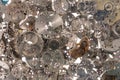 Top view of heap of metal internal parts of an old clock on a white light background. Silver clockwork with gears and