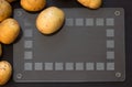 Top view of heap of unpeeled raw potato on black background