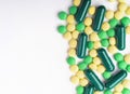 A top view of a heap of yellow and green medicine pills and capsules. Royalty Free Stock Photo