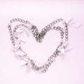 Top view of heart made of chain necklace on light pink background, square. Valentine`s Day, love, wedding or romance