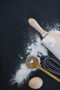 top view heart shape spoon whisk flour egg rolling pin black background. High quality photo Royalty Free Stock Photo
