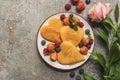 Top view of heart shaped pancakes with berries on grey concrete surface near rose Royalty Free Stock Photo