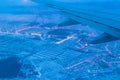 Top view from a height of flight on the night city from the window of the plane. part of an airplane wing in the frame Royalty Free Stock Photo