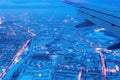 Top view from a height of flight on the night city from the window of the plane. part of an airplane wing Royalty Free Stock Photo