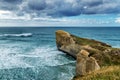 Top view of high sandy cliff and waves of Pacific ocean at Tunnel beach, New Zealand