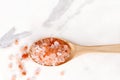 Top view of himalayan pink salt in wooden spoon on white marble table Royalty Free Stock Photo