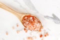 Top view of himalayan pink salt in wooden spoon on white marble table Royalty Free Stock Photo