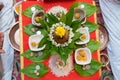 top view of hindu pooja arrangements done using betel leafs, flowers, coconut, rice and areca nuts which means supari