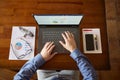 Top view of hipster vintage wooden desktop workplace. Male hands typing on a laptop. Businessman working on computer at Royalty Free Stock Photo