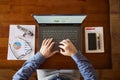 Top view of hipster vintage wooden desktop workplace. Male hands typing on a laptop. Businessman working on computer at Royalty Free Stock Photo