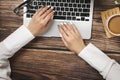 Top view of hipster wooden workspace, office table desk. Flat lay view of woman hands working on a laptop. Office work. Royalty Free Stock Photo