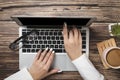 Top view of hipster wooden workspace, office table desk. Flat lay view of woman hands working on a laptop. Office work. Royalty Free Stock Photo