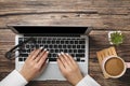 Top view of hipster wooden workspace, office table desk. Flat lay view of woman hands working on a laptop. Office work. Royalty Free Stock Photo