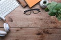 Hipster workspace with laptop computer, glasses, headphone, houseplant and notebook on wooden table. Royalty Free Stock Photo