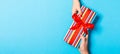 Top view of holding a gift in female and male hands on colorful background. Woman and man give and receive a present. Time for