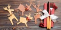 Top view of holiday objects on wooden background. Utensils tied up with ribbon on napkin. Close up of christmas decorations and