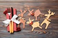 Top view of holiday objects on wooden background. Utensils tied up with ribbon on napkin. Close up of christmas decorations and