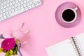 Top view of home office desk with laptop, notebook, headphones, computer mouse and rose on pink paper background Royalty Free Stock Photo