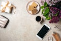 Top view home office desk workspace. Flat lay wallet, gift box, coffee cup, smartphone, perfume bottle, glasses, lilac flowers. Royalty Free Stock Photo