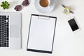 Top view of home office desktop workspace with supplies, phone, coffee and blank paper in the middle. Modern minimal design Royalty Free Stock Photo