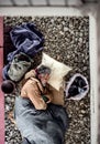 A top view of homeless beggar man lying on the ground outdoors in city, sleeping. Royalty Free Stock Photo
