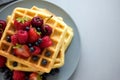 Top view on homemade belgian waffles with berries on gray table. Healthy breakfast concept Royalty Free Stock Photo